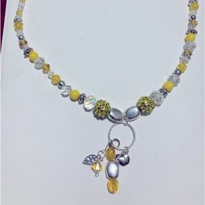 Handmade, beaded, and charmed necklace. Original design. Yellow, silver, clear